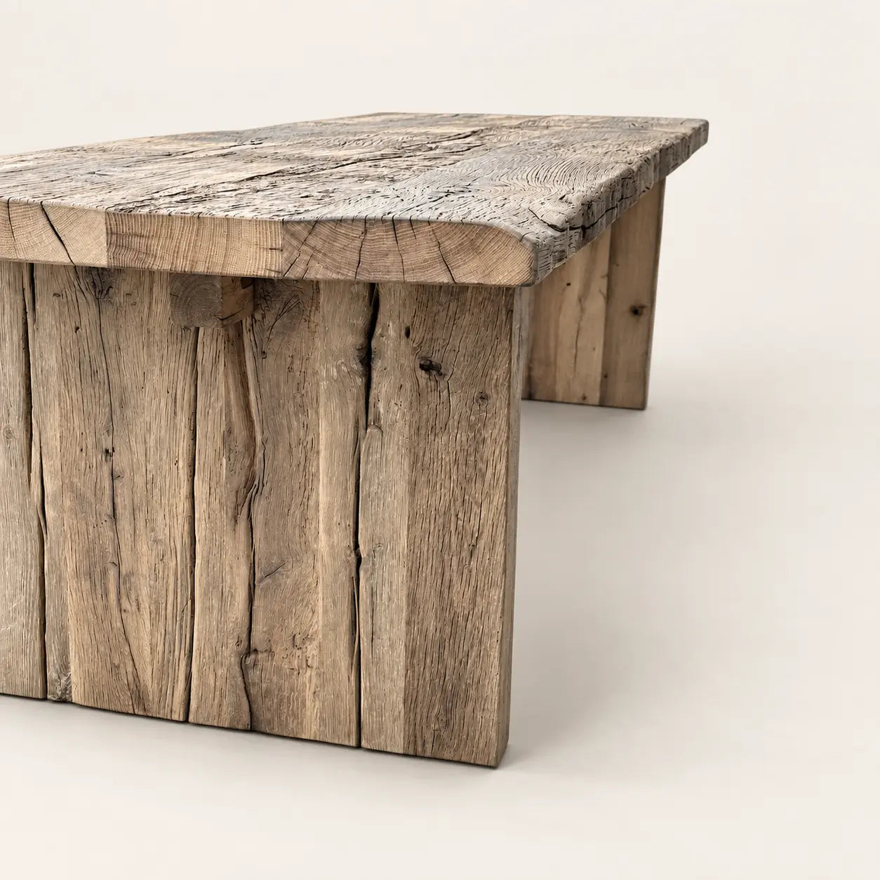 Détail de la table Bastide : chant du plateau, veinures, fissures visibles et piètement plein en bois.