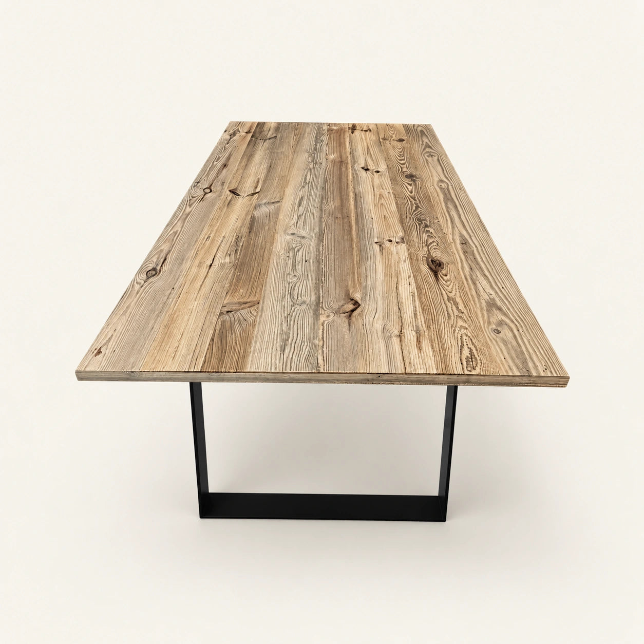 Table Alpine vue depuis une extrémité sur fond clair, avec plateau rectangulaire et piètements noirs.